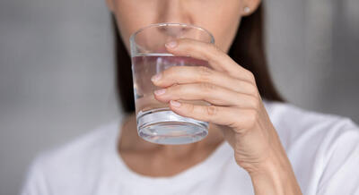 Kvinna med glas med dricksvatten i handen